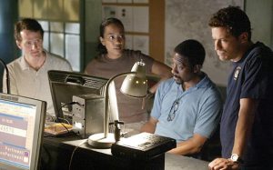 Prez, Kima, Lester, and Jimmy monitor the wire in the MCU office.